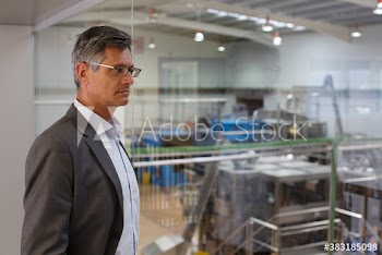 Serious businessman supervising factory floor