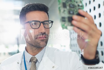 Serious male engineer examining circuit board