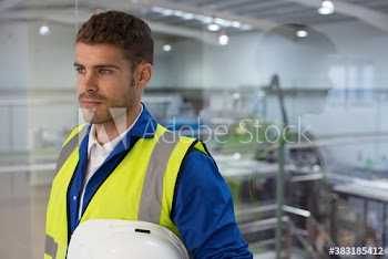 Serious male factory worker looking away