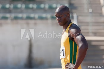 Serious male track and field athlete on sunny running track