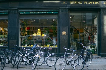 Several Assorted-color Bikes Parked in Front of Bering Flowers Facade