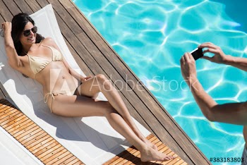 Sexy young woman in bikini posing on sunny lounge chair