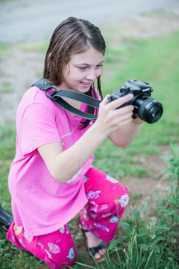 Shallow Focus Photo of a Girl in Pink Round-neck Shirt Holding Black Dslr Camera
