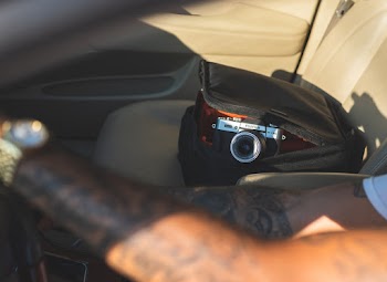 Shallow Focus Photo of Black Camera in Black Leather Bag