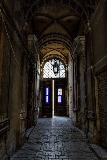 Shallow Focus Photo of Black Wooden Open Door At The End Of A Hallway Of An Old Building