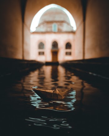 Shallow Focus Photo of Brown Paper Boat on Body of Water