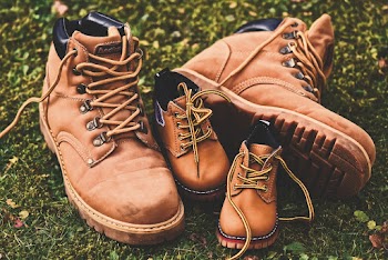 Shallow Focus Photo of Brown Work Boots on Grass 