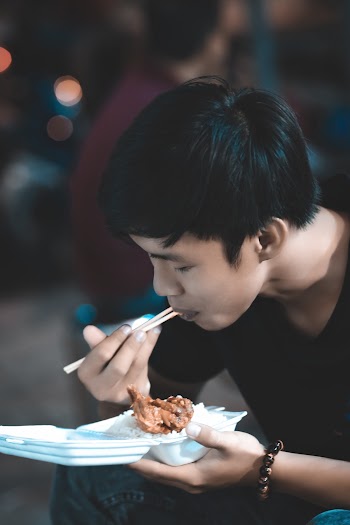 Shallow Focus Photo of Man Eating