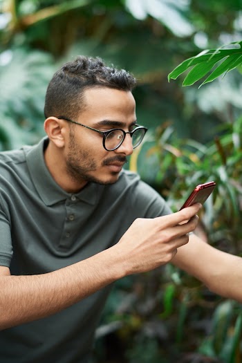 Shallow Focus Photo of Man Holding a Smartphone