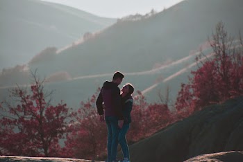 Shallow Focus Photo of Man Hugging Woman