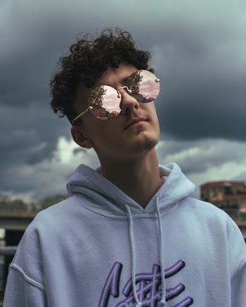 Shallow Focus Photo of Man in White Hoodie Wearing Sunglasses