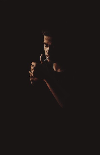 Shallow Focus Photo of Man Smoking Cigarette