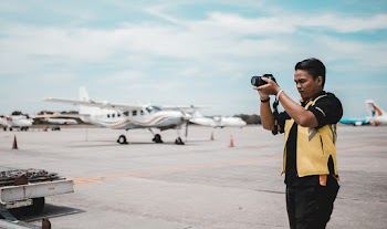 Shallow Focus Photo of Man Using Black Dslr Camera