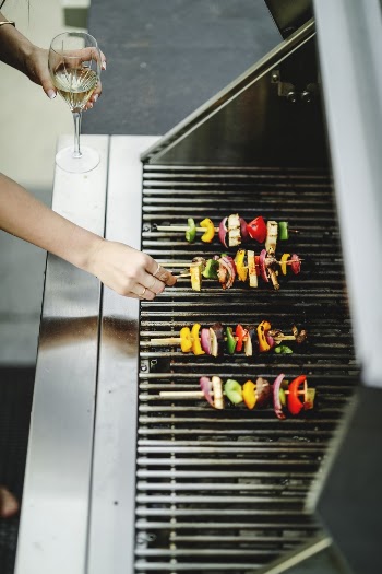 Shallow Focus Photo of Person Grilling Food on Stick