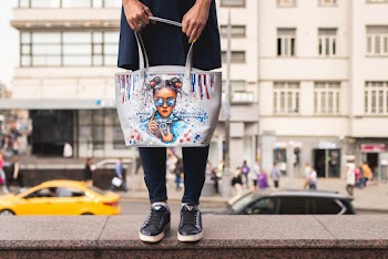 Shallow Focus Photo of Person Holding White and Blue Leather Tote Bag