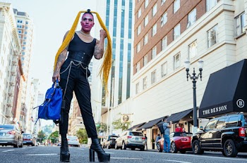 Shallow Focus Photo of Person in Black Sleeveless Shirt Standing Near Parked Cars