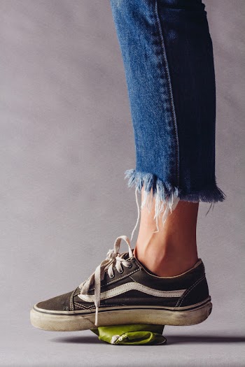 Shallow Focus Photo of Person Stepping on Green Can