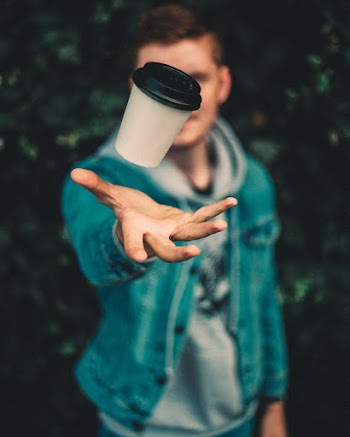 Shallow Focus Photo of Person Throwing White Plastic Cup