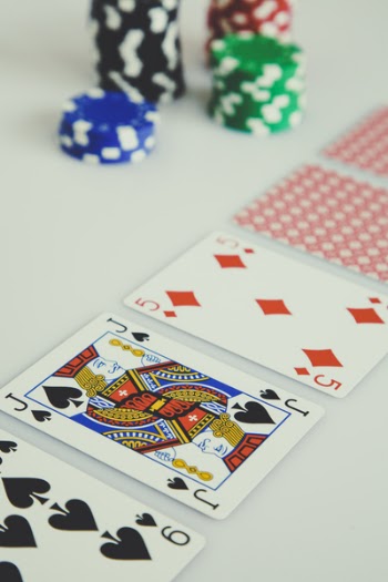 Shallow Focus Photo of Playing Cards Near Poker Chips