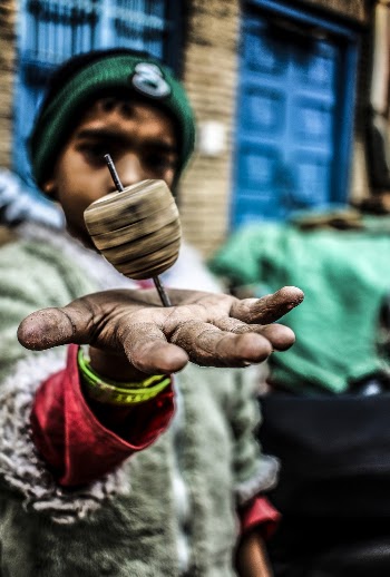 Shallow Focus Photo of Spinning Top Toy on Boy's Hand