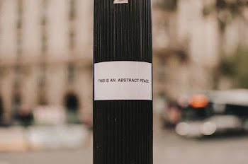 Shallow Focus Photo of White Sticker on Pole