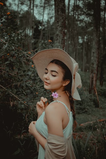Shallow Focus Photo of Woman Holding a Flower