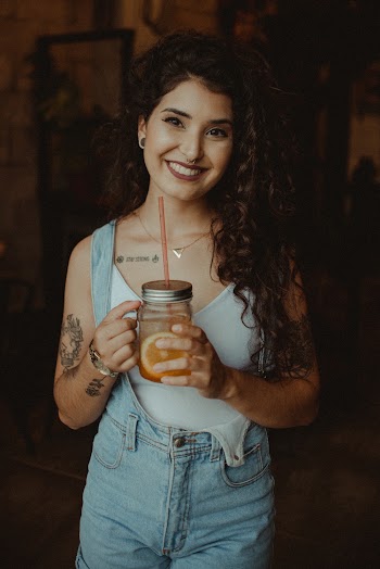 Shallow Focus Photo of Woman Holding Clear Glass Jar