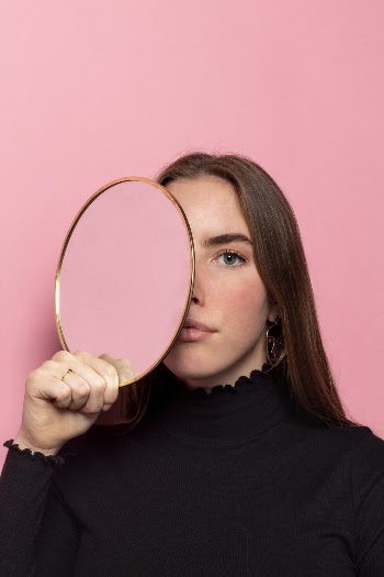 Shallow Focus Photo of Woman Holding Oval Mirror