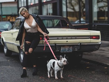 Shallow Focus Photo of Woman Holding White Dog Leaning on Car