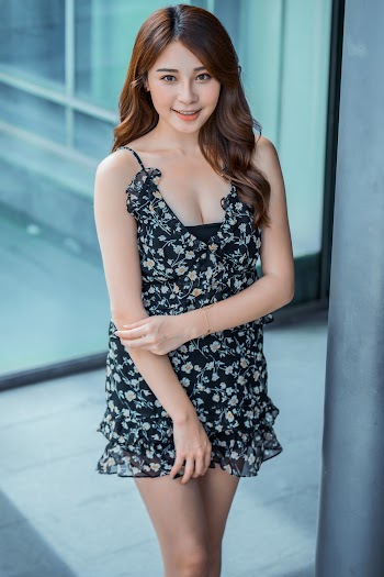 Shallow Focus Photo of Woman in Black and White Floral Spaghetti Strap Dress