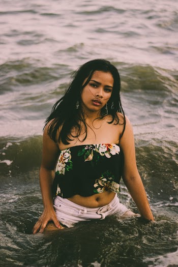 Shallow Focus Photo of Woman in Black and White Floral Strapless Crop Top on Body of Water