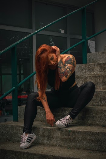 Shallow Focus Photo of Woman in Black Spaghetti Strap Top Sitting on Stairs