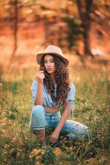 Shallow Focus Photo of Woman in Blue Off-shoulder Crop Top Wearing Brown Wide Brim Fedora Hat
