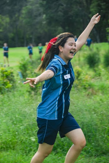 Shallow Focus Photo of Woman in Blue Polo Shirt Raising Left Hand