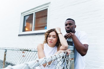 Shallow Focus Photo of Woman in White Sleeveless Shirt Beside Man