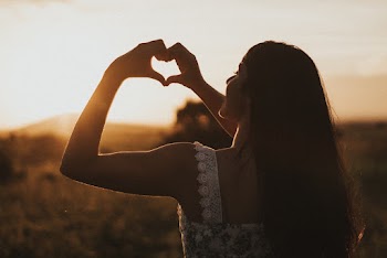 Shallow Focus Photo of Woman in White Thick Strap Top Showing Heart Hand Gesture