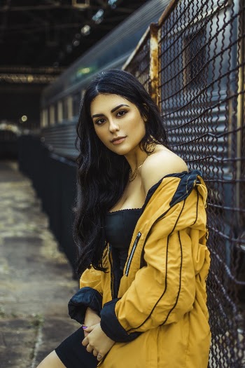 Shallow Focus Photo of Woman Leaning on Fence