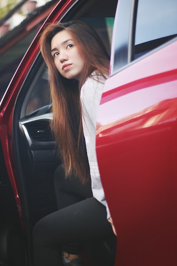 Shallow Focus Photo Of Woman Riding A Red Car