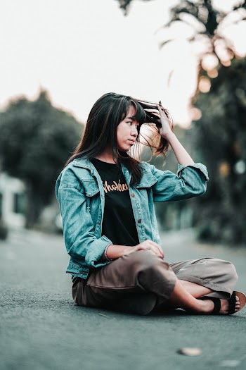 Shallow Focus Photo of Woman Sitting on Ground