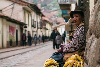 shallow focus photo of woman sitting on house front