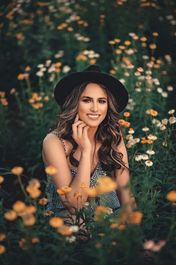 Shallow Focus Photo of Woman Sitting While Wearing Black Hat