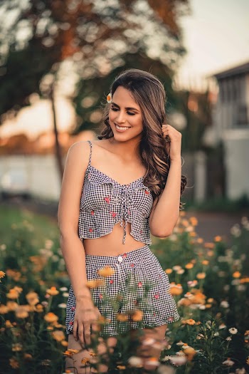 Shallow Focus Photo of Woman Smiling While Standing on Flower Field