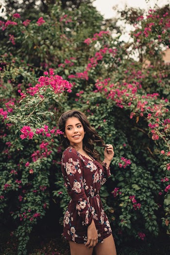 Shallow Focus Photo of Woman Standing Near Pink Flowers
