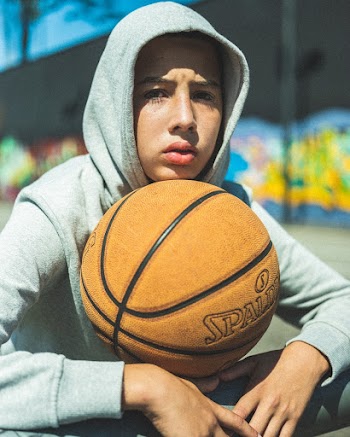 Shallow Focus Photography Man Carrying Brown Spalding Basketball