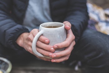 Shallow Focus Photography of a Person Holding White Ceramic Mug