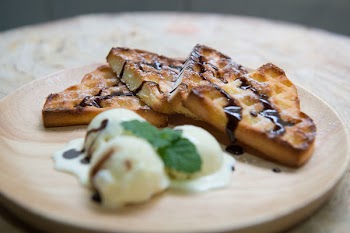 Shallow Focus Photography of Baked Bread With Chocolate Syrup Serve on Wooden Plate