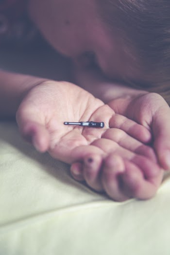 Shallow Focus Photography of Black Plastic Toy on Boy's Palm