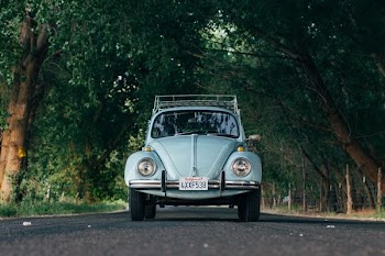 shallow focus photography of blue beetle car