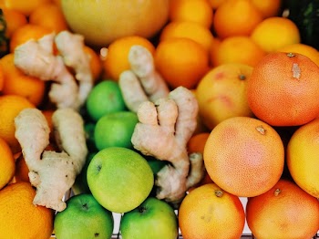 Shallow Focus Photography of Ginger Root and Persimmons