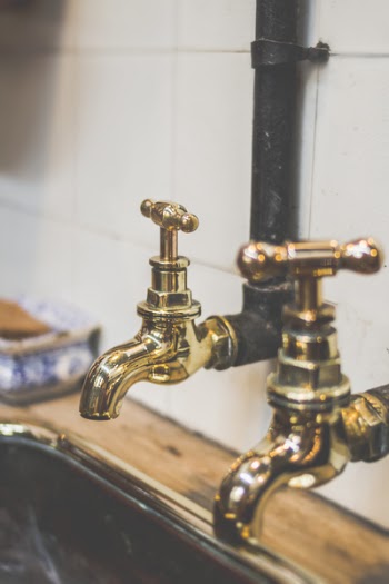 Shallow Focus Photography of Gold Faucets